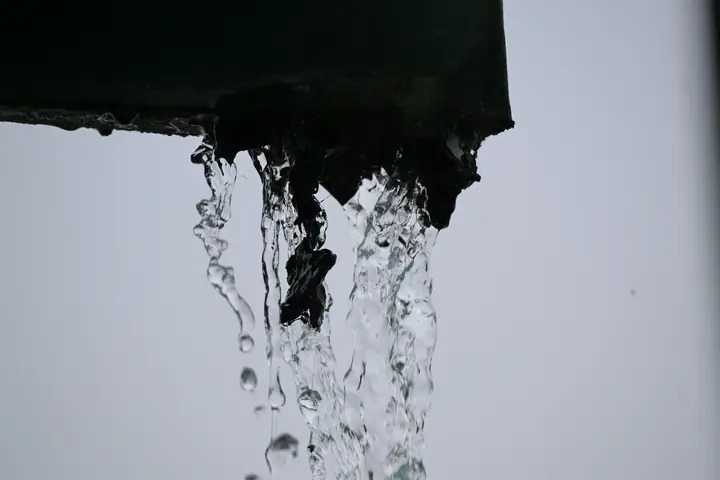 Agua que cae de una canaleta metálica
