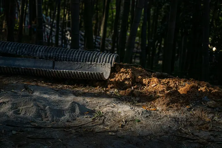 Tubo de drenaje que descarga tierra en un camino