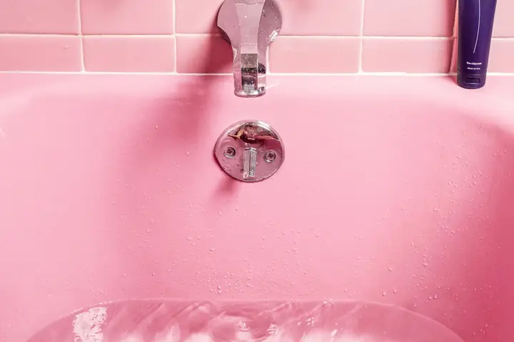 Tina con agua estancada sobre el desagüe