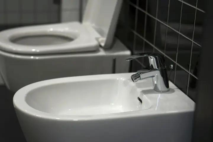 WC junto a un lavamanos en un baño blanco